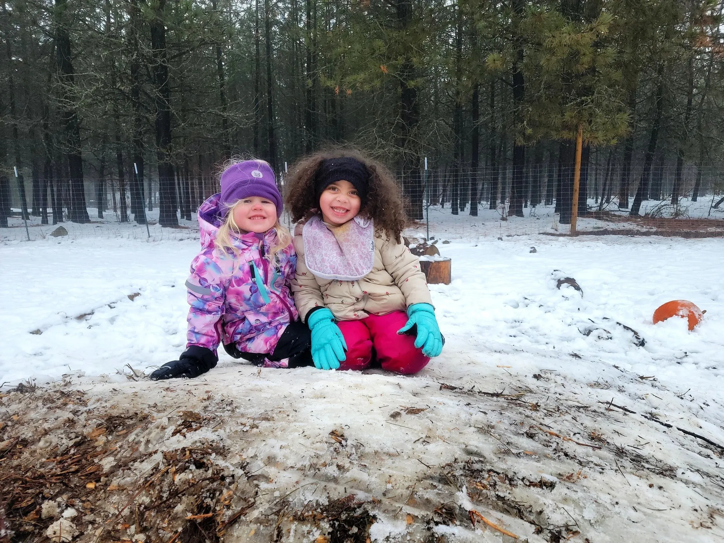 Two friends sitting together in the snow